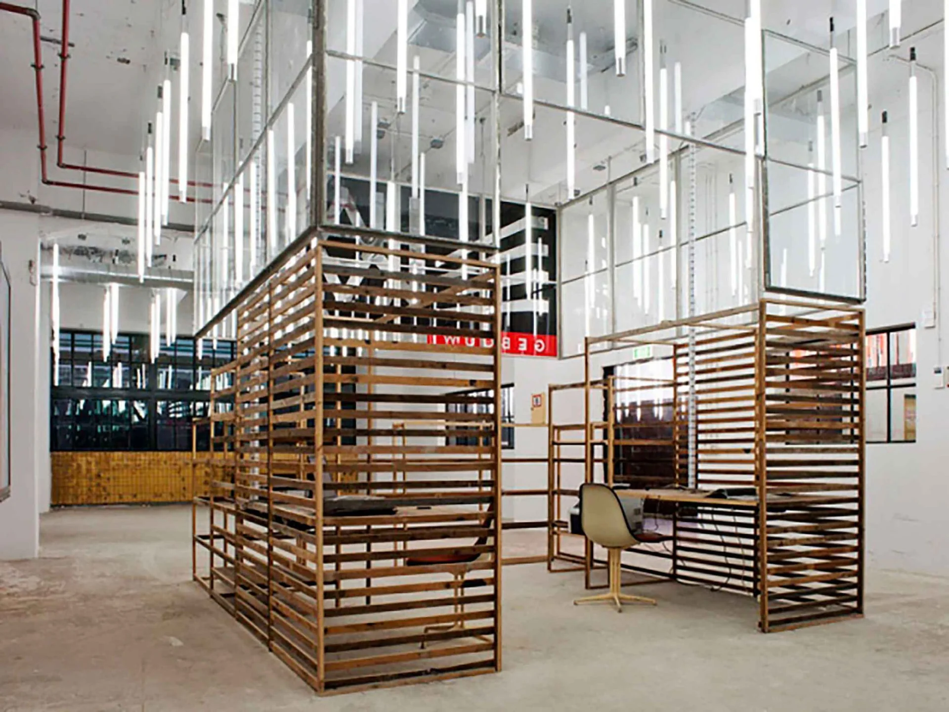 Werkplekken van hergebruikt hout in het lichte industriële interieur van het HAKA-gebouw