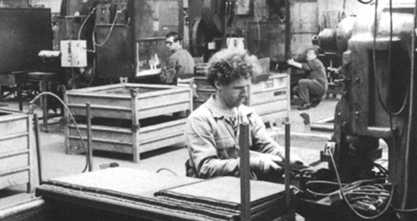 Medewerkers tussen machines in de historische productiehal van Galvanitas