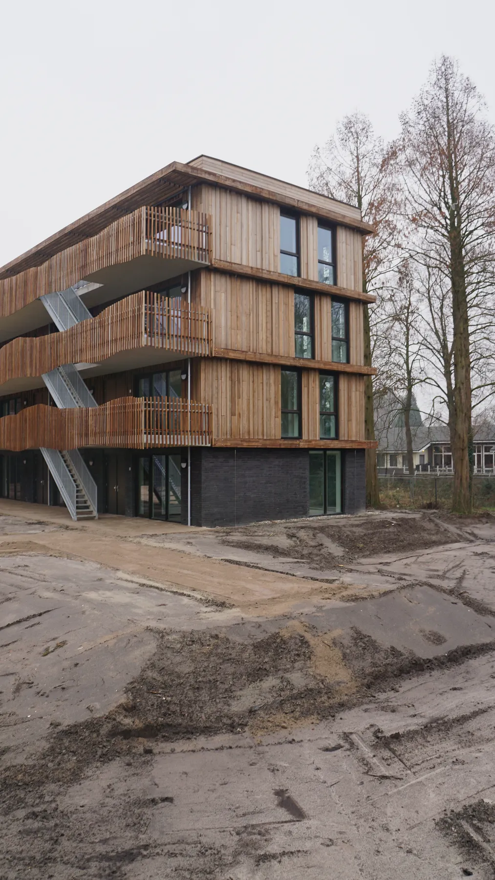 Nieuw woongebouw van Viertien met houten gevels tussen de bomen