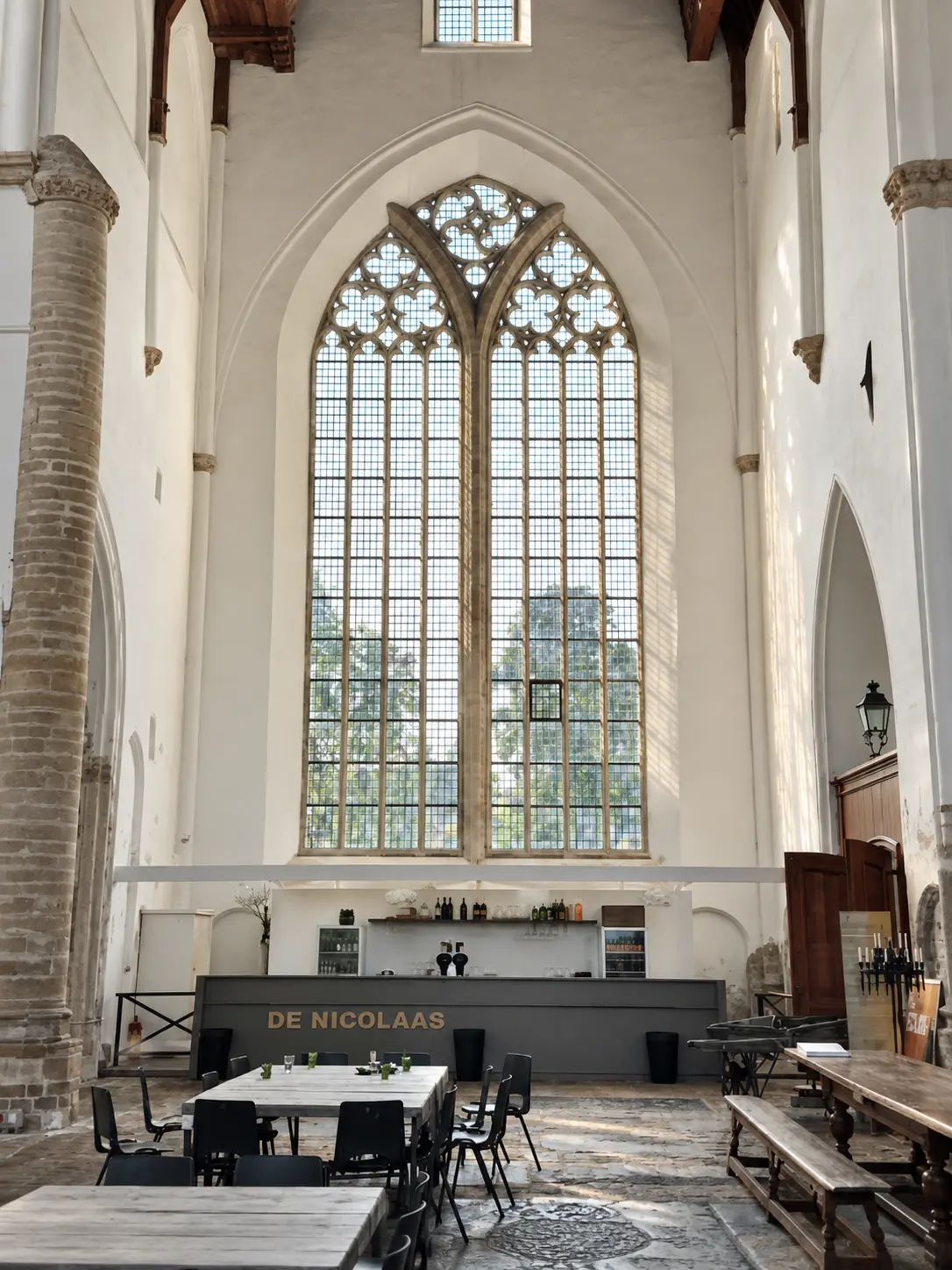 Licht interieur van de Nicolaaskerk in Brouwershaven met het hoge gotische venster boven de ontmoetingsruimte