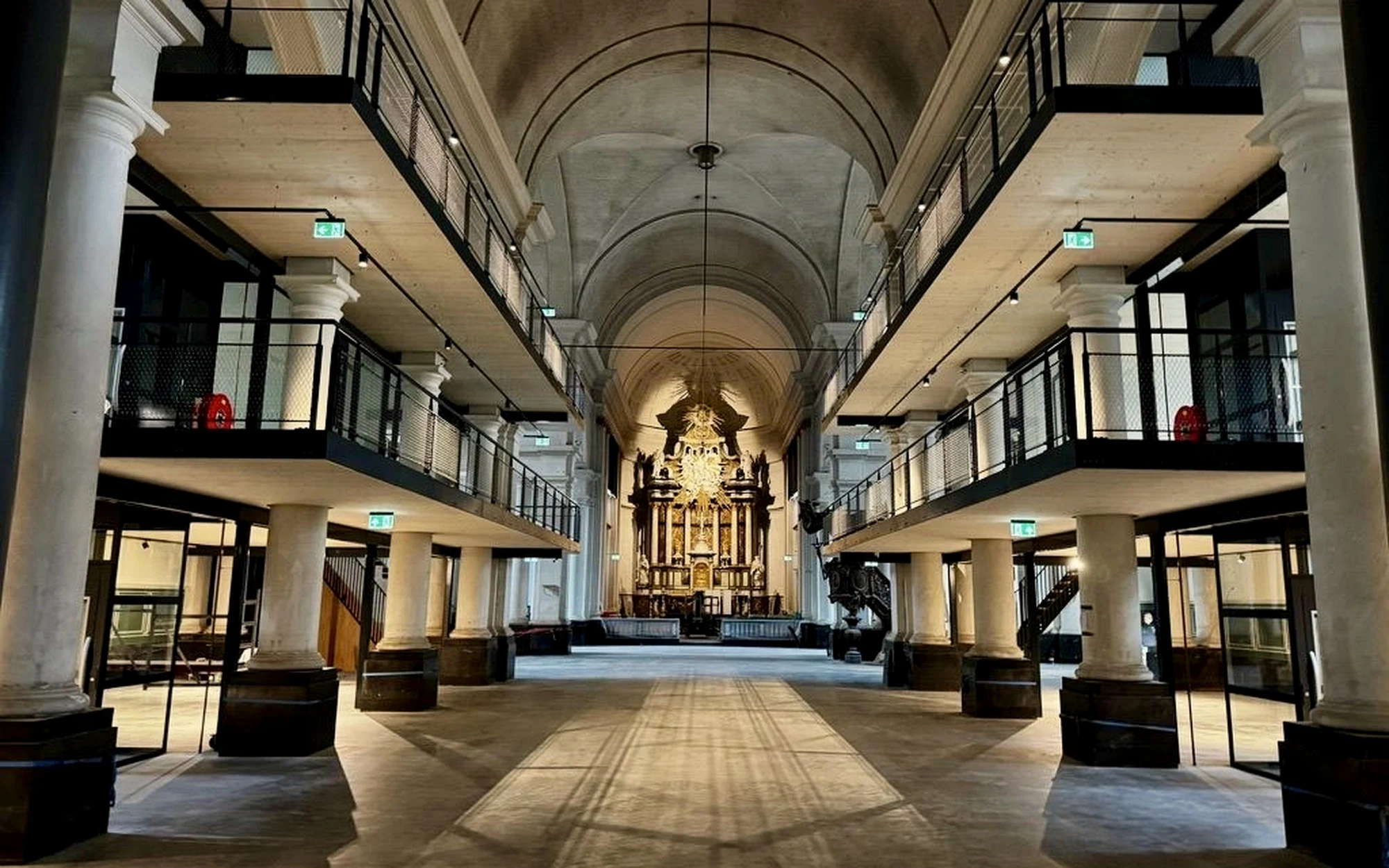 Het middenschip van de Sint Jan de Doperkerk in Roosendaal met nieuwe verdiepingen langs de zijbeuken en het historische altaar op de achtergrond