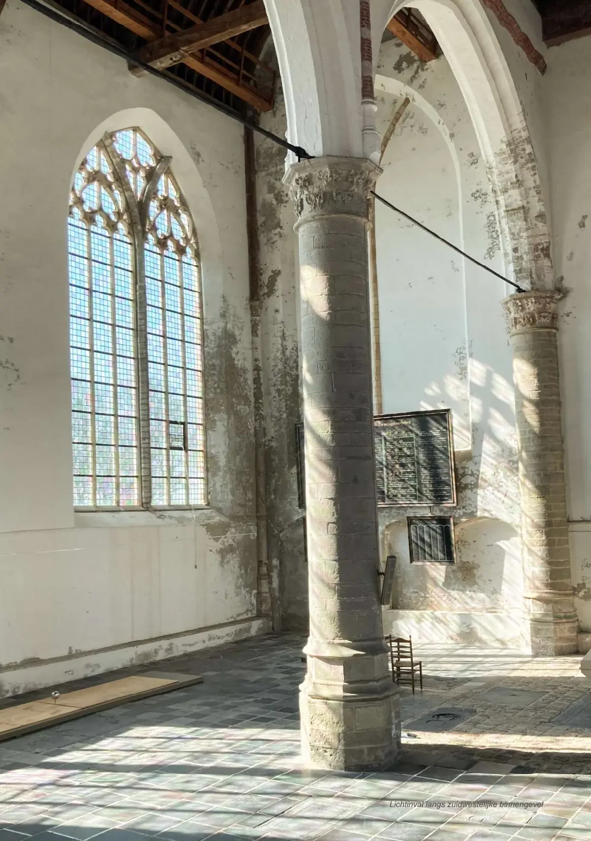 Lichtval langs de hoge vensters en zuilen in het interieur van De Nicolaas